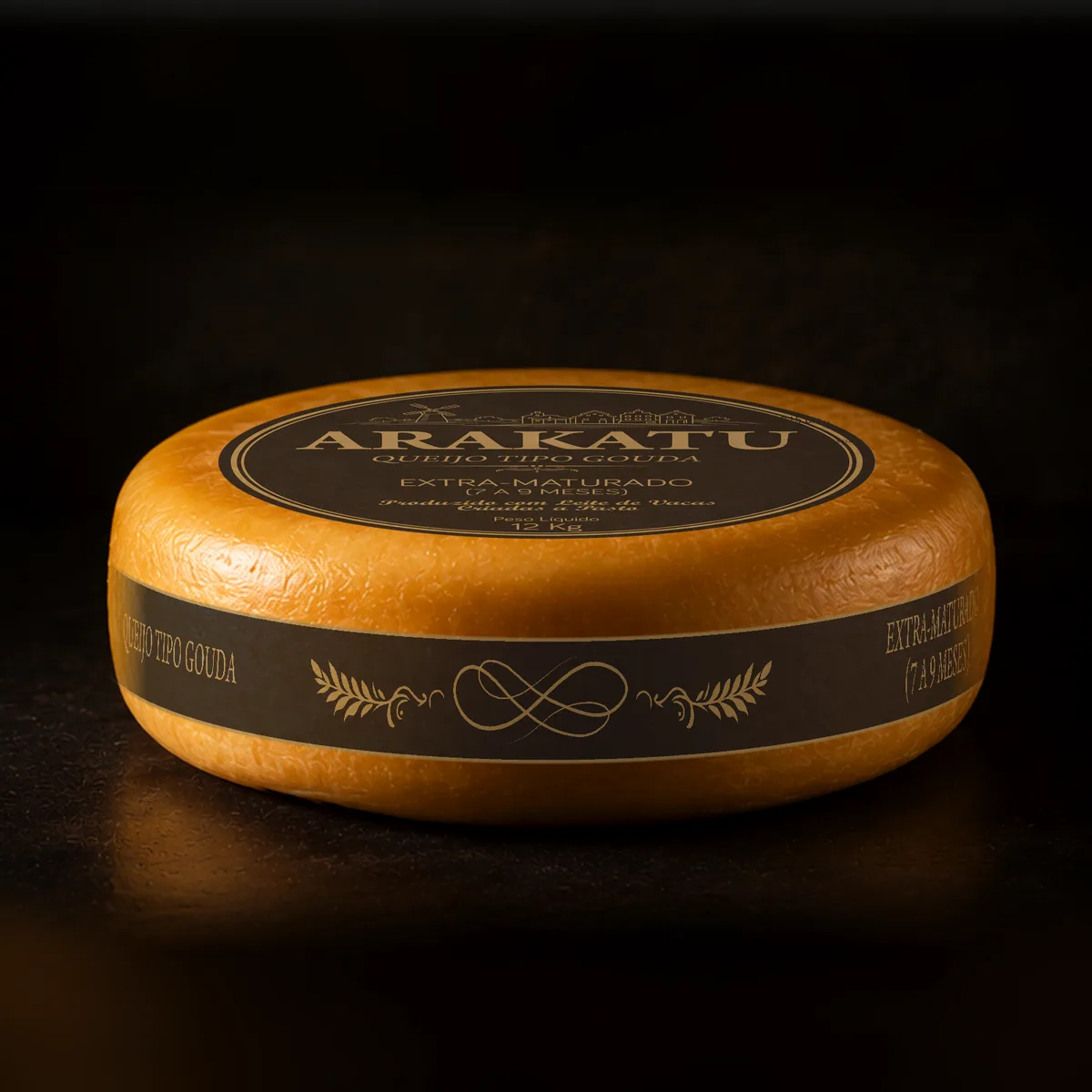 Roda inteira de queijo tipo Gouda Arakatu Extra-Maturado, rótulo escuro, sobre fundo escuro